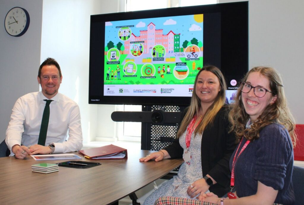 Minister Morgan at a desk in conversation with the Gemma Bailey and Eleanor Wills