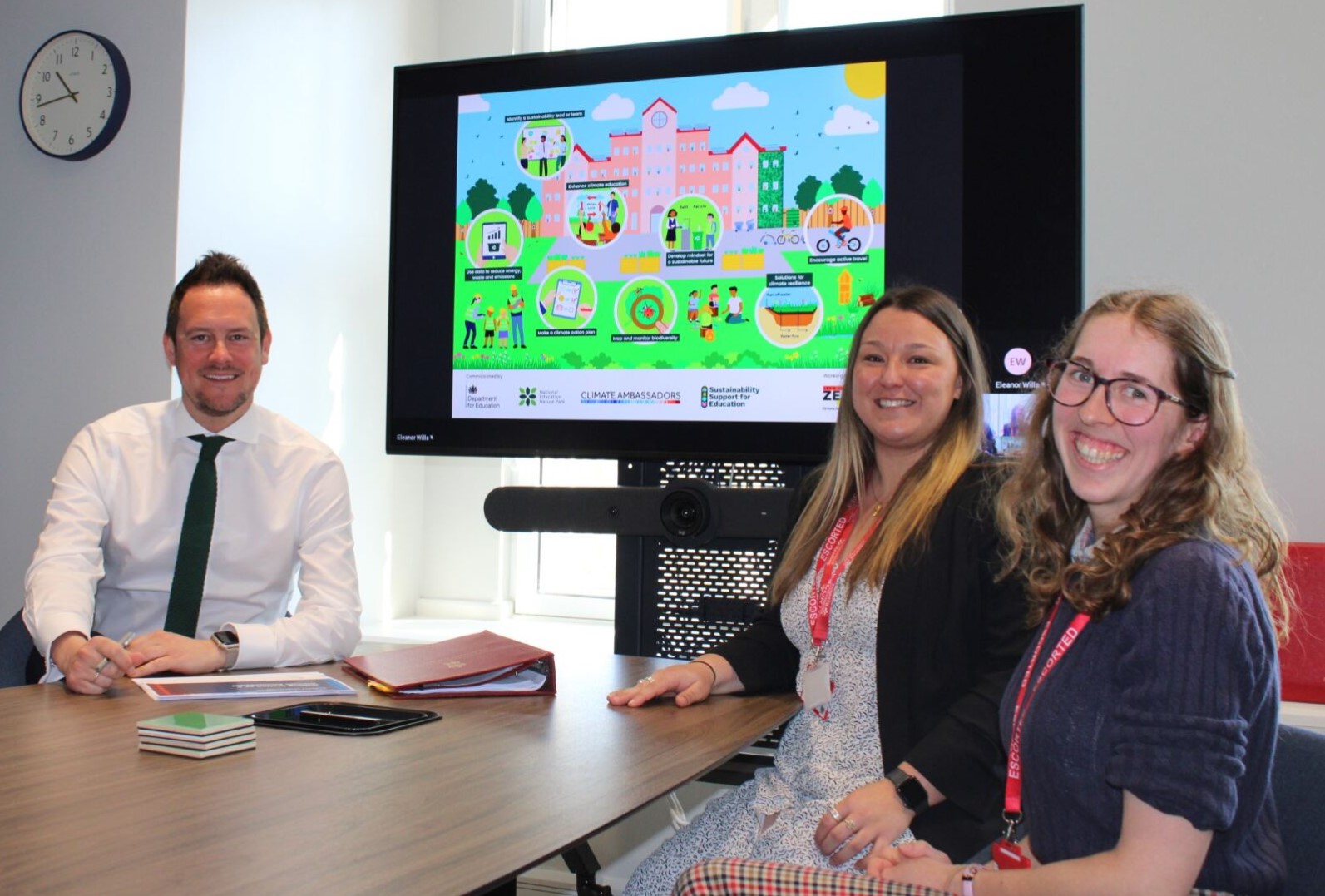 Minister Morgan at a desk in conversation with the Gemma Bailey and Eleanor Wills
