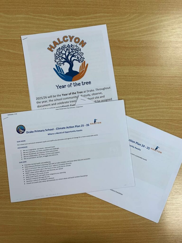 Three documents on a wooden surface, including “HALCYON Year of the Tree” and Drake Primary School’s Climate Action Plan for 2025–26.